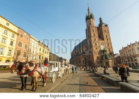 KRAKOW, POLAND - FEB 7, 2015: St. Mary's Church in historical center of Krakow on Main Square - dates to the 13th century, and at roughly 40,000 m it is the largest medieval town square in Europe.