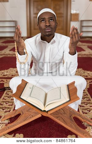 Young African Muslim Guy Reading The Koran