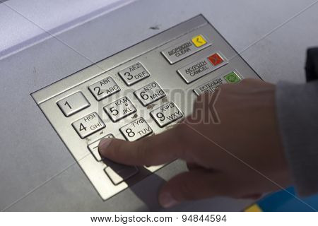 People Stand In A Queue To Use The Atms Of A Bank. Person Receiving Money From The Atm.