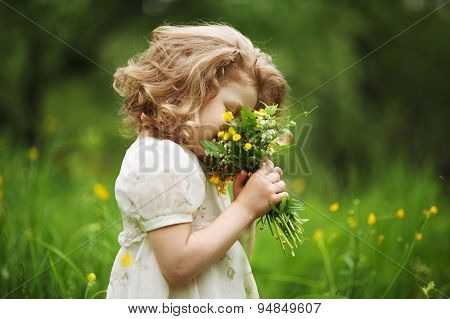 Little Girl Smelling A Bouquet Of Flowers