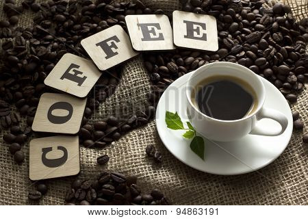 Cup of coffee and coffee beans letters