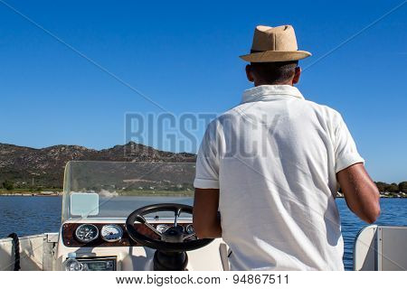 Man Driving A Boat Near The Coast