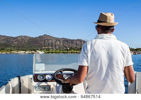 Man Driving A Boat Near The Coast