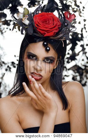 pretty brunette woman with rose jewelry, black and red, bright make up kike a vampire closeup