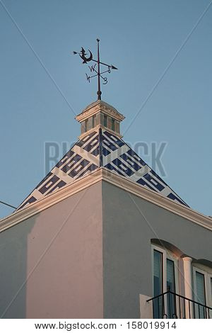 the weather vane on the roof of a beautiful house in Spain