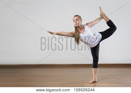 Young fit woman works out in the fitness class. Yoga asana. Space for placing text.