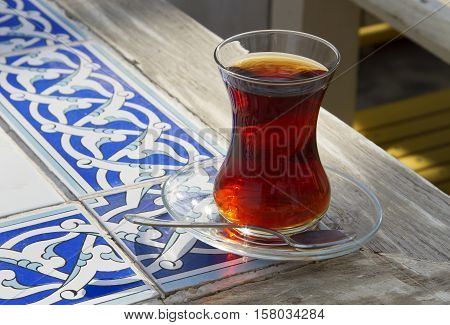 Traditional turkish glass of tea on the old wooden table