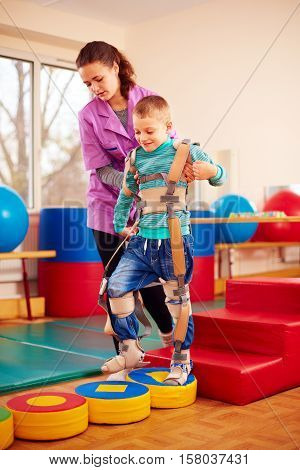 Cute Kid Having Physical Musculoskeletal Therapy In Rehabilitation Center