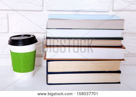 Stack of books and a cup of coffee in the office. Copy space
