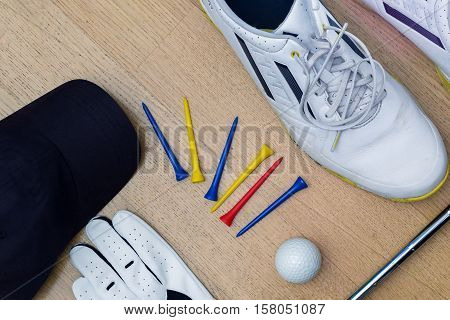 a view of variuos golf tools like shoes tees glove ball and cap