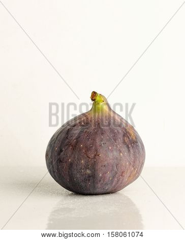 Ripe fruit fig closeup on a light background with reflection