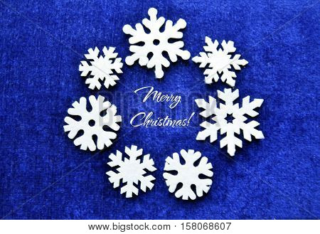 Merry Christmas blue background with decorative felt snowflakes.Festive christmas decorations.Christmas wreath of snowflakes.Winter holidays background.Selective focus.