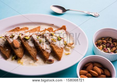 Shahi Tukda prepared - deep fried bread in ghee, garnish with sweetened cream and dry fruits.