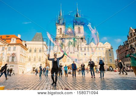Prague, Czech Republic - October 15, 2014: Unidentified Young Woman Makes Soap Bubbles In Old Town Square - Staromestske Namesti. Church Of Our Lady Before Tyn On Background.