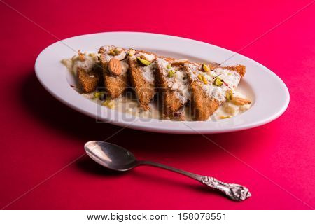 Shahi tukda prepared - deep fried bread in ghee, garnish with sweetened cream and dry fruits.