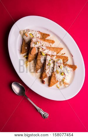 Shahi tukda prepared - deep fried bread in ghee, garnish with sweetened cream and dry fruits.