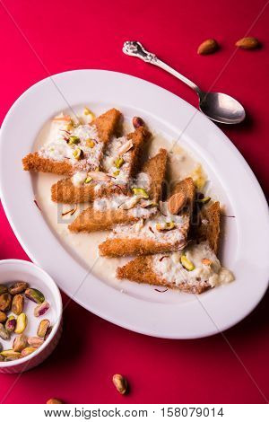 Shahi tukda prepared - deep fried bread in ghee, garnish with sweetened cream and dry fruits.