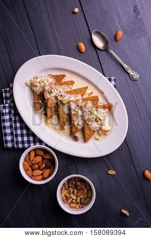 Shahi tukda prepared - deep fried bread in ghee, garnish with sweetened cream and dry fruits.