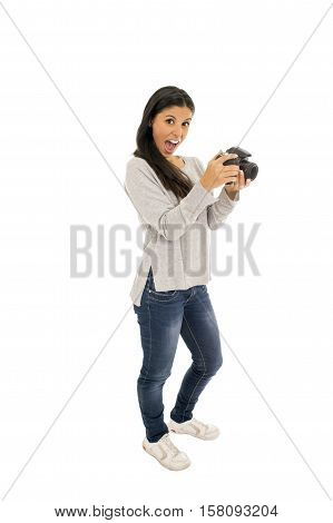 portrait of young beautiful and exotic hispanic photographer woman smiling happy and relaxed isolated on white background taking photos with photographic reflex camera excited and cheerful