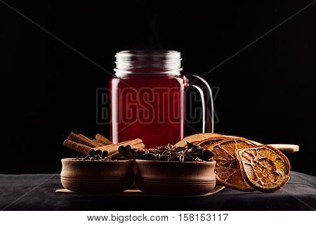 Christmas food - mulled wine. Decorative composition of spices hot drink on dark black background. Cooking of beverage.