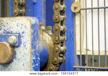 Closeup dirty ratchet gear with chain drive in metal processing