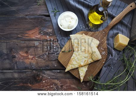 Focaccia with olive oil parmesan cheese white sause and rosemary. Homemade traditional Italian bread focaccia on the linen napkin.