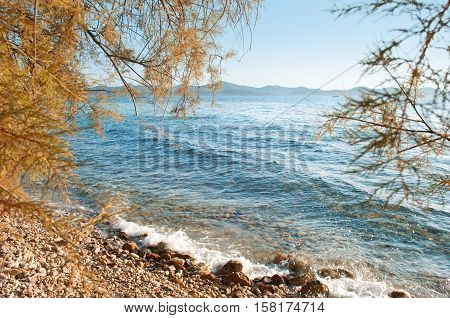 Zadar seaside on a summer evening. Waves crashing against pebble shore