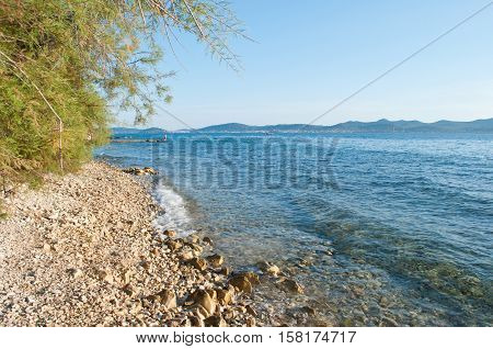 Zadar seaside on a summer evening. Waves crashing against pebble shore