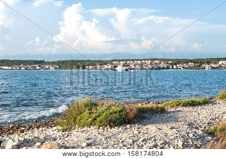 A small ship sailing along Zadar town in a deep blue sea water. Sunny summer day fluffy clouds in the sky