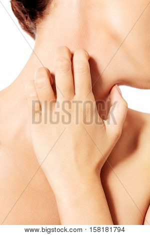 Topless woman scratching her neck.