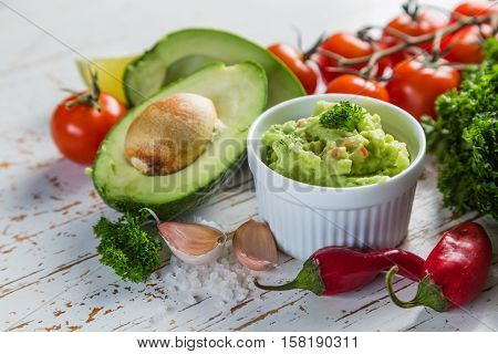 Guacamole sauce and indredients on wood background, copy space