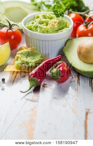 Guacamole sauce and indredients on wood background, copy space