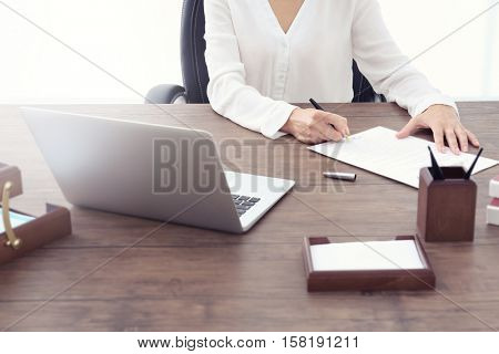 Female lawyer signing documents in office