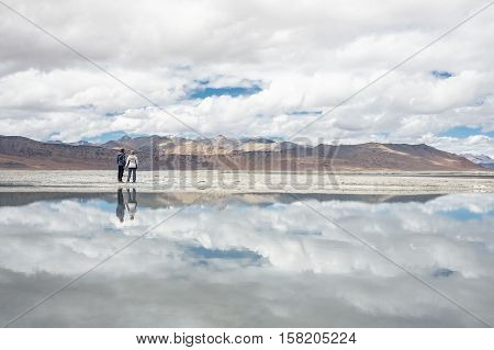 Two travelers stay near the Tso Kar Lake in Himalaya India Ladkh region