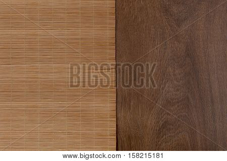Bamboo mat on wooden table. Top view. Bamboo and wood texture background.