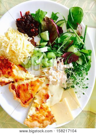 Golden cooked quiche with cheese and salad