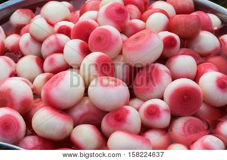 Pickled onions in red vinegar close up