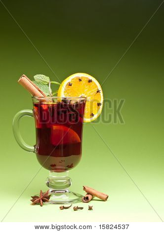แก้วเขียว mulled บนพื้นหลังสีเขียว