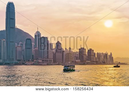 Star Ferry In Victoria Harbor And Hong Kong Skyline At Sundown
