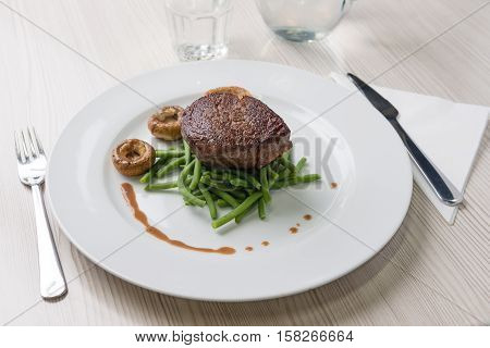 Delicious sirloin steak with green beans and mushrooms
