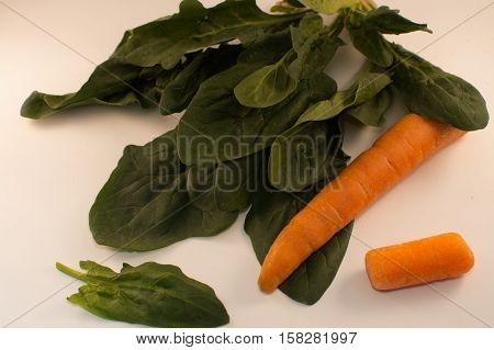carrots and spinach on a white background