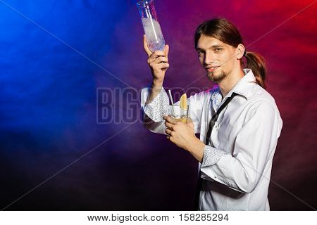Flair bartending alcohol liquor party concept. Barman showing his skills. Young male tapster makes cocktail.