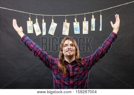 Riches and fortune. Young happy man with a lot of money on black background. Winning the lottery concept.