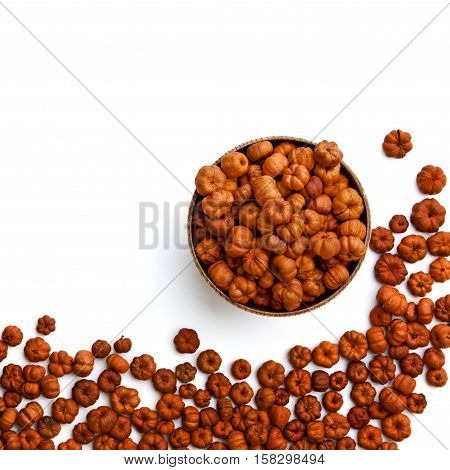 Heap of tiny red and orange pumpkin putka pods on white and in bowl. Autumn Fall Halloween harvest concept. Square frame background with copy space for text.