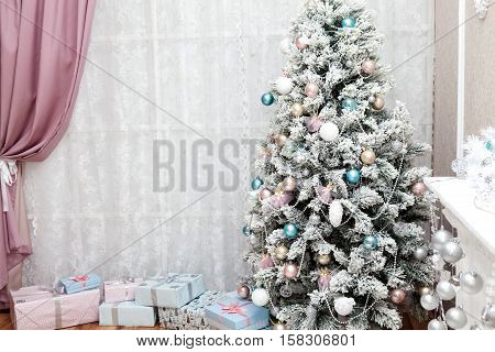 Beautiful holdiay decorated room with Christmas tree with presents under it