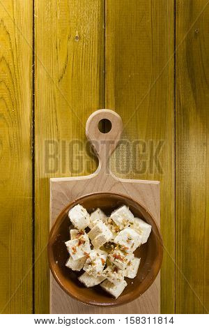 Bryndza sheep cheese in a clay plate on a wooden background