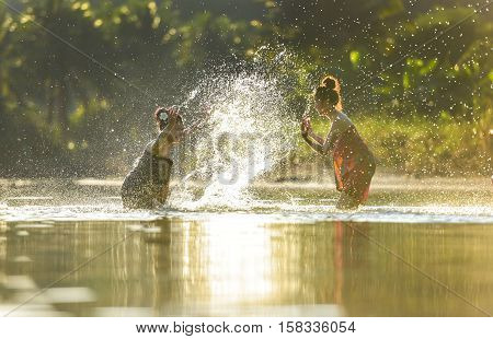 Girls swimming in a canal in Laos.