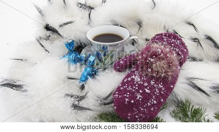 Winter background coffee mug snow, candy, ermine and mitten