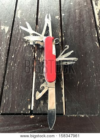 pocket army knife on dark wooden table