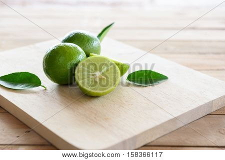 Lemons with green leaf on wooden background